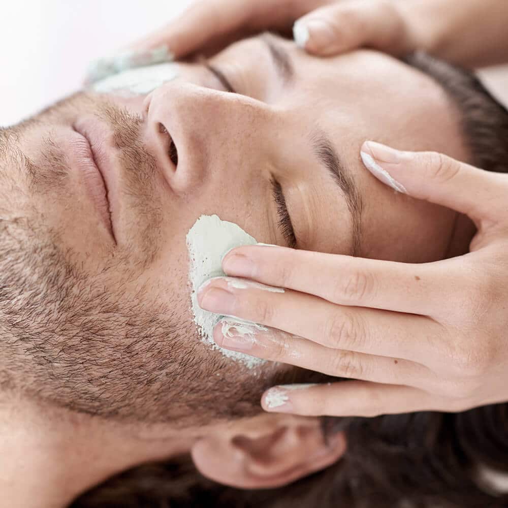 Mand får en ansigtsbehandling med maske